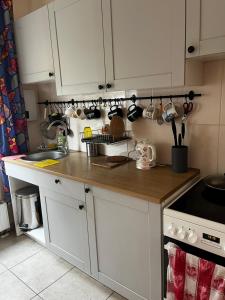 a kitchen with white cabinets and a wooden counter top at Cosy house in Center of Tartu in Tartu