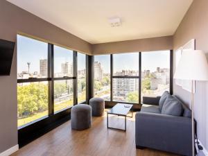 Una sala de estar con un sofá y grandes ventanales. en Live Soho Boutique Apartments Belgrano, en Buenos Aires
