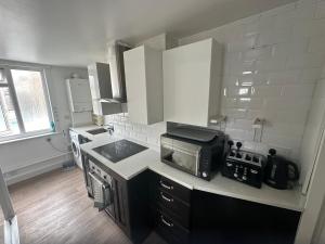 a kitchen with a microwave and a stove top oven at 120 Mortimer St, Herne Bay in Kent