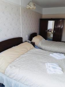 a bedroom with two beds and a mirror at Royal Hotel Great Yarmouth in Great Yarmouth