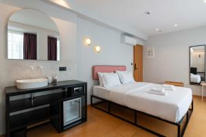 ein Schlafzimmer mit einem Bett, einem Waschbecken und einem Spiegel in der Unterkunft PAREA Athens in Athen