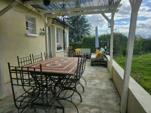 une terrasse avec une table et des chaises dans une maison dans l'établissement La Bretèche, Gîte au cœur des châteaux de La Loire, à Saint-Martin-le-Beau