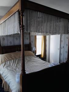 a bedroom with a canopy bed and a window at Royal Hotel Great Yarmouth in Great Yarmouth