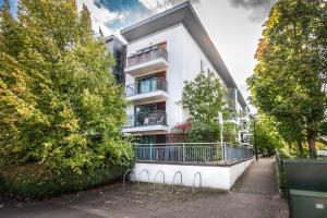 a white building with trees in front of it at Accessible 2 bedrooms flat + P in Southampton