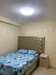 a bedroom with a bed with a blue comforter at DEPARTAMENTO con COCHERA en Chimbote in Chimbote