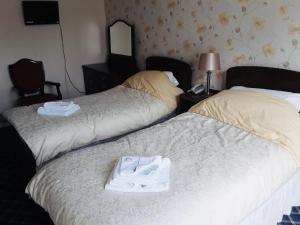 two beds in a hotel room with a pair of shoes at Royal Hotel Great Yarmouth in Great Yarmouth