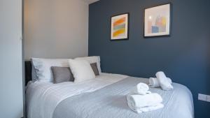 um quarto azul com uma cama com toalhas em 2 BDR apartment at QUEENS UNI by Belfast City Breaks em Belfast