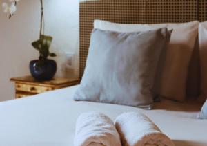 Una cama con dos toallas enrolladas. en Calador Búzios Hotel, en Búzios