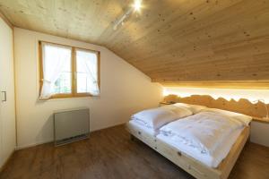 Cama en habitación con techo de madera en Schönau en Wildhaus