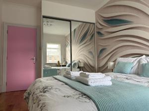 a bedroom with a large bed with a purple door at Rosie Cosy House Cricklewood in London +30 photos