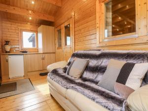 Una sala de estar con un sofá y una cocina. en Chywolow Lodge, en Morvah