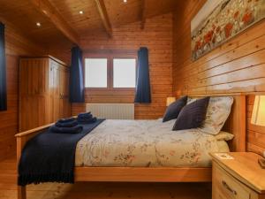 a bedroom with a bed in a wooden cabin at Chywolow Lodge in Morvah