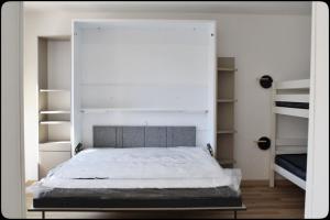 ein Schlafzimmer mit einem großen weißen Bett und Regalen in der Unterkunft Spacious cocoon in Six-Fours-les-Plages in Six-Fours-les-Plages + 24 Fotos