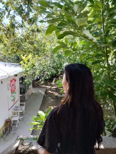 uma mulher a olhar pela janela para um jardim em Casa Nuestra Hostal em Salta