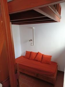 a bed in a room with two orange pillows at Σπιτι Χωρα Πατμου in Patmos