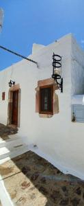 a white building with two windows and a street light at Σπιτι Χωρα Πατμου in Patmos