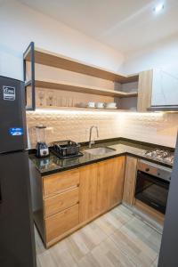 a kitchen with a sink and a refrigerator at EXCLUSIVO LOFT. CAOBOS COLIVING&COWORKING. ZONA T in Cúcuta