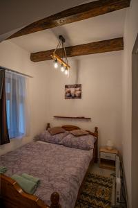 una camera con letto e lampadario a braccio di Forrás Vendégház Maconka a Bátonyterenye
