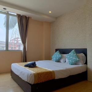 um quarto com uma cama com almofadas azuis e uma janela em The Patioz Boutique Hotel em Kajang