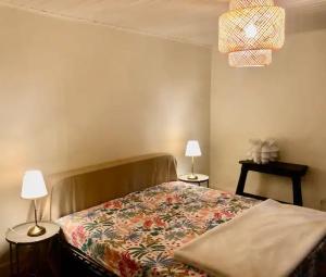 - une chambre avec un lit, 2 tables et 2 lampes dans l'établissement Le Rocher, à Sarlat-la-Canéda