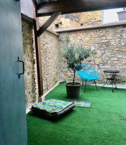 une chambre avec de l'herbe verte, une table et une plante dans l'établissement Le Rocher, à Sarlat-la-Canéda