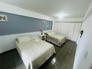 Duas camas num quarto com paredes azuis em Confortável quarto e sala com Manobrista, Wi-fi, Tv Smart - Apto 208 em Maceió