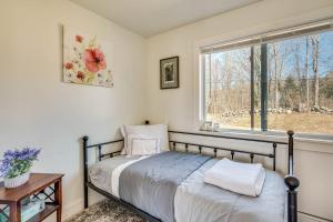 um quarto com uma cama e uma janela em Over Andover Retreat with Hot Tub Walk to Lake! em Andover