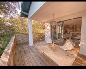 een terras met 2 stoelen en een tafel bij Chambre dans villa avec piscine in Seignosse