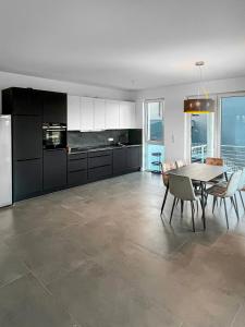 Luxus Neubauwohnung mit Blick auf den Phönix-See في دورتموند: مطبخ وغرفة طعام مع طاولة وكراسي