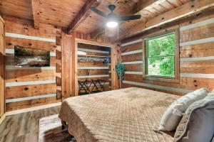 a bedroom with wooden walls with a bed and a ceiling fan at NEW! Black Bear Chalet Getaway with Games, Hot Tub, RnR, Fun in Sevierville