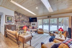 Cozy Big Bear Lake Vacation Rental Home في بيغ بير لاكي: غرفة معيشة كبيرة بجدار حجري