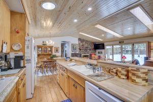 Cozy Big Bear Lake Vacation Rental Home في بيغ بير لاكي: مطبخ كبير مع دواليب خشبية وقمة كونتر