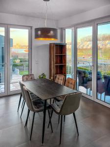 uma sala de jantar com uma mesa de madeira e cadeiras em Luxus Neubauwohnung mit Blick auf den Phönix-See em Dortmund