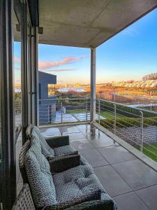 einen Balkon mit Sofa und Blick auf ein Feld in der Unterkunft Luxus Neubauwohnung mit Blick auf den Phönix-See in Dortmund