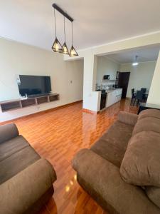 CASTELLARES LA PUEBLA APARTAMENT في اياكوتشو: غرفة معيشة مع أريكة وتلفزيون بشاشة مسطحة