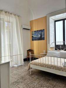 Schlafzimmer mit einem Bett und einem Fenster in der Unterkunft Il Teatro Rooms in Catania