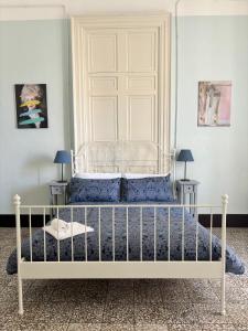 ein Schlafzimmer mit einem weißen Bett mit blauer Bettwäsche in der Unterkunft Il Teatro Rooms in Catania