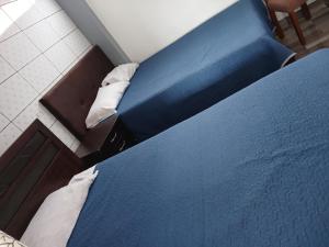 a blue bed with two pillows in a room at Hospedaje dominguez in Oxapampa