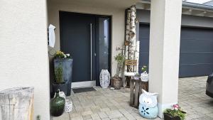 a front door of a house with plants and vases at Gästehaus Ferienwohnung Abendstern in Rust