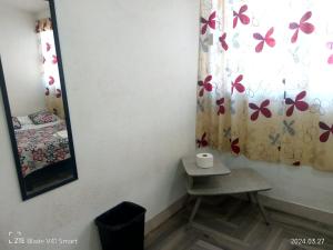 uma casa de banho com um espelho, uma cama e cortinas em Alojamiento GAMA em Cidade do México
