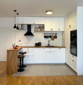 cocina con armarios blancos y encimera en Comfy apartment near La Defense - West of Paris en La Garenne-Colombes