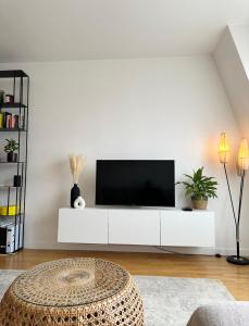 sala de estar con TV en una pared blanca en Comfy apartment near La Defense - West of Paris en La Garenne-Colombes