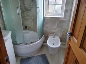La salle de bains est pourvue d'une douche, de toilettes et d'un lavabo. dans l'établissement Primrose lodge cosy 2 bedroom house in a quiet, à Norwich