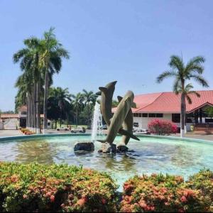 uma estátua de dois golfinhos numa fonte em 2Bdr Condo - Los Delfines Golf & Country Club - Large Patio - Beach of Playa Tambor - 24 hrs security em Pochote