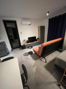 een woonkamer met een oranje bank en een tafel bij Starling in Oud-Turnhout
