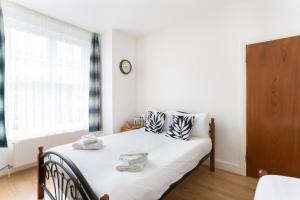 a bedroom with a bed with white sheets and a window at City Center Camden Market Budget Apartment and Rooms in London