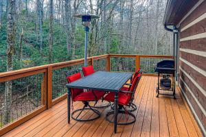 une terrasse en bois avec une table et quatre chaises dans l'établissement Bear Feet Retreat, à Banner Elk