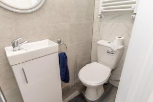 uma casa de banho com um WC branco e um lavatório. em 20 Leys Road rooms 1 - 4 em Wellingborough