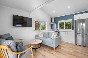 a living room with a couch and a kitchen at Tasman Holiday Parks - Beachaven in Waihi Beach