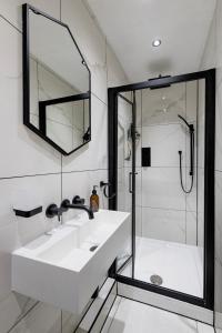 a white bathroom with a sink and a shower at London Street in Bath